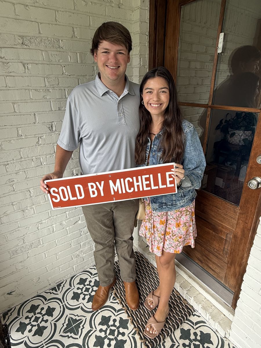 Michelle&rsquo;s clients holding a Sold by Michelle sign on a front porch