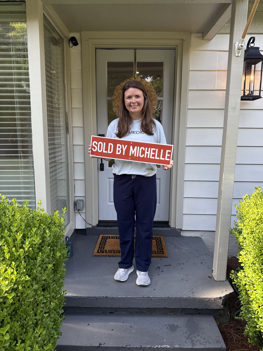 One of Michelle&rsquo;s clients holding a Sold by Michelle sign on her front steps